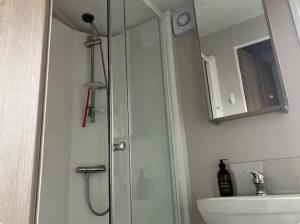 a bathroom with a shower and a sink and a mirror at Moray Coast getaway in Lossiemouth +14 photos