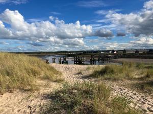 a group of people standing on a beach near the water at Moray Coast getaway in Lossiemouth