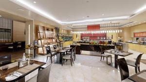 a restaurant with tables and chairs and a bar at Radisson Blu Marina Hotel Connaught Place in New Delhi