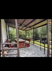 a screened in porch with a table and a grill at Csobogó Patak Vendégház in Sicasău +5 photos