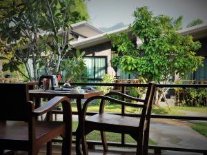 a wooden table and chairs sitting on a patio at Family House Zen Boutique Resort in Pai