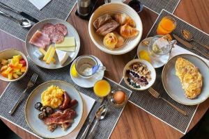 a wooden table with plates of breakfast food on it at Hotel Reine Victoria in St. Moritz