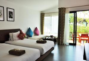 a hotel room with two beds and a balcony at Family House Zen Boutique Resort in Pai
