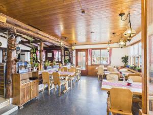 a restaurant with wooden ceilings and tables and chairs at Hotel Wildbach Brienz - Self Check-in in Brienz