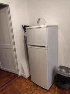 a white refrigerator in the corner of a room at Appart proche gare centre ville bureau parking in La Loupe