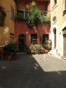 un vicolo in un vecchio edificio con alberi e piante di Suites Imperiali Guest House a Roma