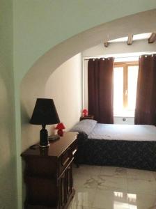 Suites Imperiali Guest House في روما: غرفة نوم بسرير وطاولة مع مصباح
