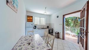 a kitchen with a table and chairs in a room at Apartman Roza 1 by Villas Guide in Vela Luka