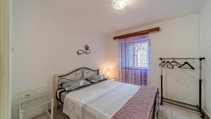 a bedroom with a bed and a window at Apartman Roza 1 by Villas Guide in Vela Luka
