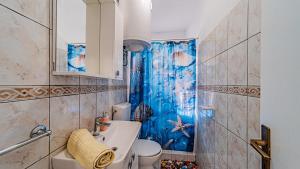 a bathroom with a toilet and a blue shower curtain at Apartman Roza 1 by Villas Guide in Vela Luka +5 photos