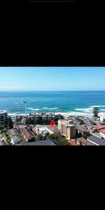 a view of a city with the ocean in the background at Top Location Beachside Apartment in Cronulla +4 photos