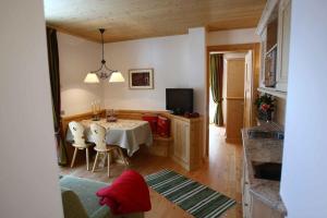 uma cozinha e sala de jantar com mesa e cadeiras em Apartments Sol E Nef em Rocca Pietore