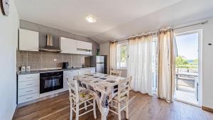 a kitchen and dining room with a table and chairs at Apartman Roza 2 by Villas Guide in Vela Luka