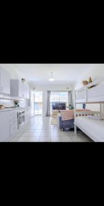 a kitchen and a living room with a bed and a couch at Top Location Beachside Apartment in Cronulla
