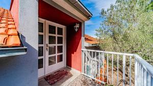 a door to a red house with a balcony at Apartman Roza 2 by Villas Guide in Vela Luka +12 photos