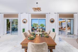 a dining room with a wooden table and chairs at Villa Verde Azura in Bin Rhilouf