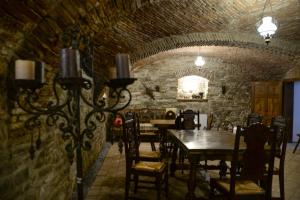 een eetkamer met tafels en stoelen en een stenen muur bij Carolina House in Sighişoara