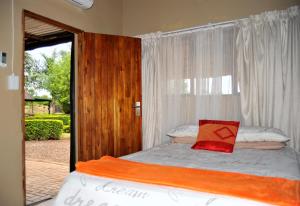 a bed in a room with a window and a bed sidx sidx sidx at Palmwag Tzaneen in Tzaneen