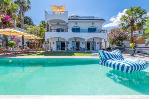 a house with a swimming pool in front of a house at Villa Verde Azura in Bin Rhilouf