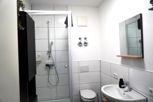 a white bathroom with a shower and a sink at Apart4me Style Apartment Geislingen zentral mit Parkplatz in Geislingen an der Steige