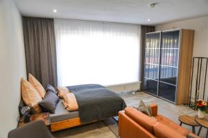 a bedroom with a bed and a living room at Apart4me Style Apartment Geislingen zentral mit Parkplatz in Geislingen an der Steige