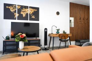 a living room with a television and a table with flowers at Apart4me Style Apartment Geislingen zentral mit Parkplatz in Geislingen an der Steige
