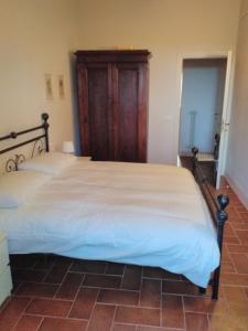 ボルゲリにあるLaurettaのベッドルーム1室(大型ベッド1台、木製ヘッドボード付)