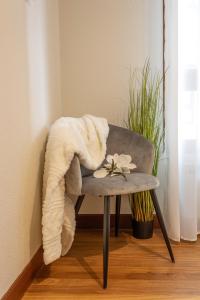 a chair with a blanket and flowers on it at Apartamento Baztangoa II Centro Elizondo in Elizondo +22 photos