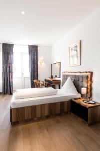 a hotel room with a large bed and a desk at Eventlocation & Hotel Schloss Neuburg in Obrigheim