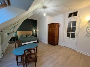 a bedroom with a bed and a table and a stairway at Domaine du moulin de la plaine in Trôo