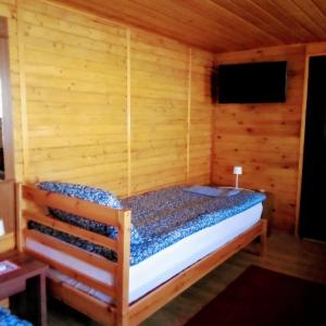 a room with a bed in a wooden cabin at Gabriella Vendégház in Vadna +4 photos