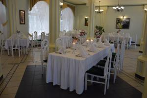 a dining room with white tables and white chairs at Roskosz Zespół Dworsko Parkowy in Biała Podlaska
