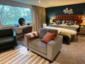 a bedroom with a bed and a couch and a chair at The Conningbrook Hotel in Ashford +39 photos