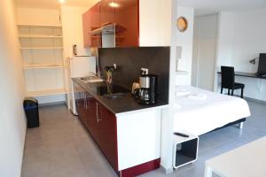 a kitchen with a counter and a bed in a room at Apt'art Pompidou Metz in Metz