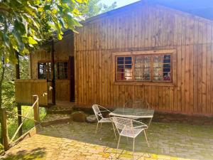 a table and chairs in front of a wooden building at Backpackers at Kanaan in Hazyview