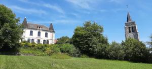 a large white house with a steeple and a church at Les Tourelles in Contes