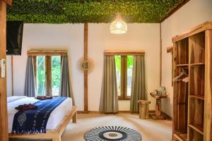 a bedroom with a bed in a room with iv ceilings at Beda gaya ecolodge Rangsot 2 in Tanjung