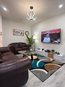 a living room with a couch and a flat screen tv at Maxti Guest Suite, Northwest Calgary in YYC