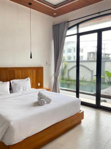 a bedroom with a large bed and a large window at Twin House Villa in Canggu