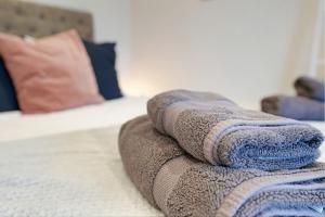 a pile of towels sitting on top of a bed at Stylish Bakewell apartment -walk to cafes and river in Bakewell