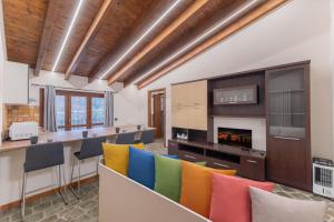 a room with colorful chairs and a bar with a fireplace at EasyHome Malpensa Milano - self-check-in in Somma Lombardo