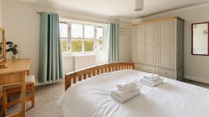 a bedroom with a white bed with towels on it at New Haven in Elie