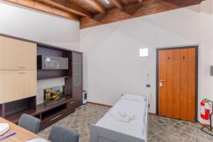 a living room with a television and a table and chairs at EasyHome Malpensa Milano - self-check-in in Somma Lombardo