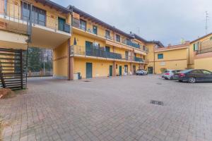 a large building with cars parked in a parking lot at EasyHome Malpensa Milano - self-check-in in Somma Lombardo