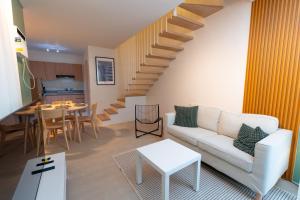a living room with a white couch and a staircase at Verdant Villas in Kaybagal