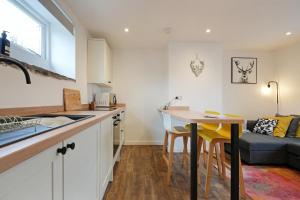 a kitchen and living room with a table and a couch at Stylish Bakewell apartment -walk to cafes and river in Bakewell