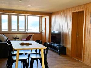 a dining room with a table and chairs and a television at Apartment Büel in Krattigen in Krattigen