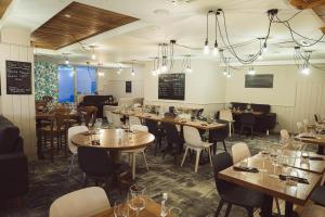 a restaurant with tables and chairs and a chalkboard at Appart' du Trident in Mulhouse