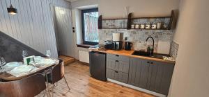 a kitchen with a counter and a sink and a table at Rest & Relax Górzyniec in Piechowice