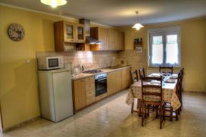 a kitchen with a table and a white refrigerator at Apartman Anka in Ratkovica
